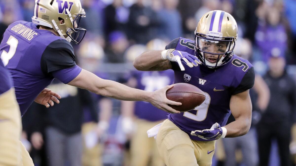 Washington running back Myles Gaskin scans the line of scrimmage for an opening as he takes a handoff from quarterback Jake Browning during a game against Oregon State on Saturday in Seattle.