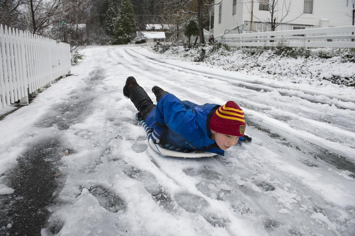 Alexander Hagen, 10, sleds down School Street in his historic Placer County community on Thursday, Dec. 24, 2015, in Dutch Flat, Calif.