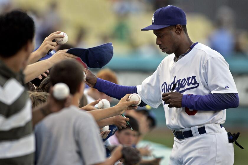 DeAratanha, Ricardo –– – Digital Image taken on Monday, 07/03/2006, Los Angeles, CA – Photo by Ricardo DeAratanha/Los Angeles Times –– Dodgers player Kenny Lofton signing autographs for fan before a game against the Arizona Diamondbacks on Monday, July 3, 2006 at Dodgers Stadium.