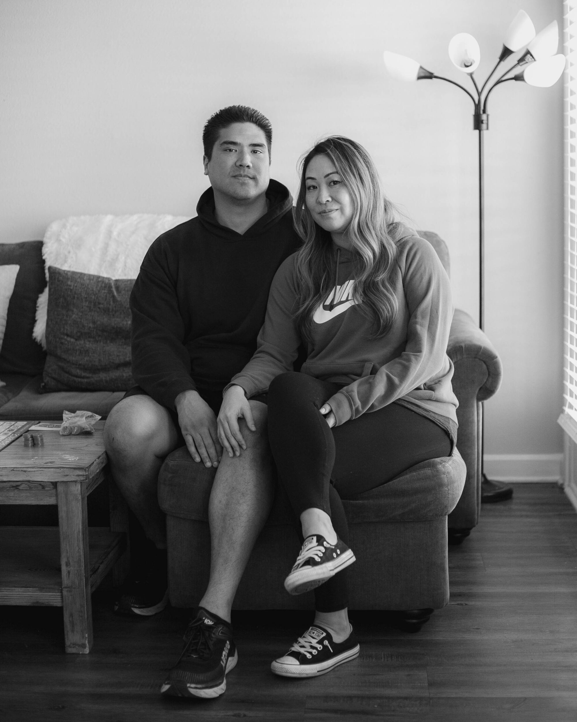 A couple sits on a couch.