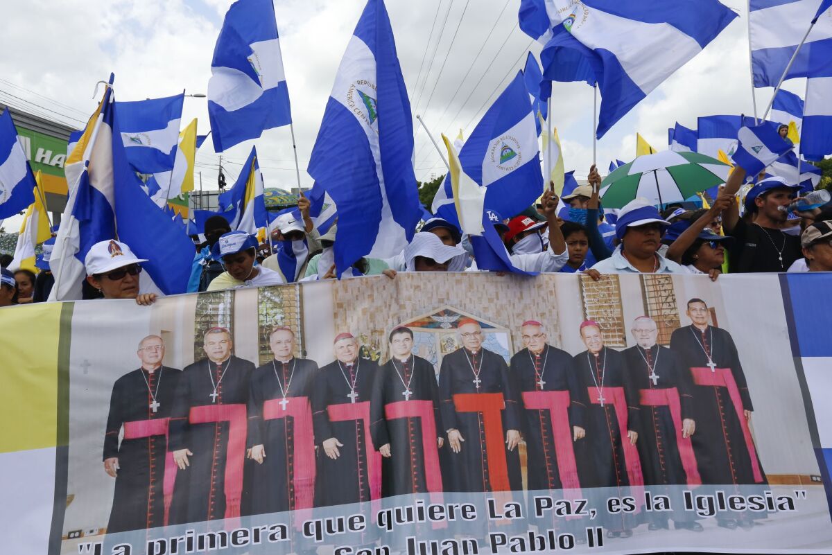 Demonstrators hold a banner featuring a group of Catholic cardinals.