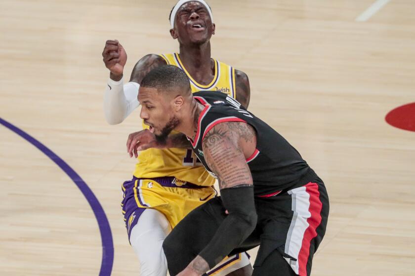 Lakers guard Dennis Schroder fouls Trail Blazers guard Damian Lillard as he drives during a game at Staples Center.