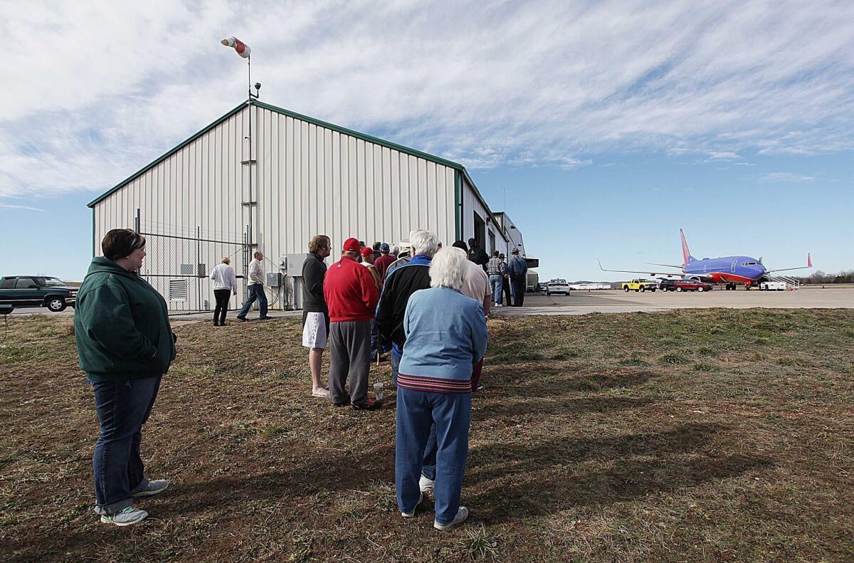 A small crowd gathers at the M. Graham Clark Airport in Hollister, Mo., to see a Southwest Airlines jet that landed there by mistake.