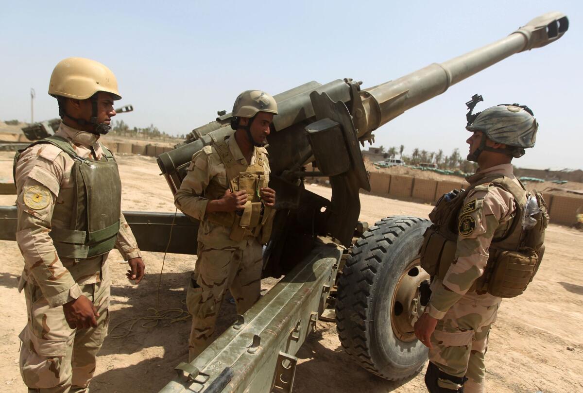Iraqi forces stand next to an M198 howitzer as they fire artillery toward Islamic State positions west of Baghdad on April 20.