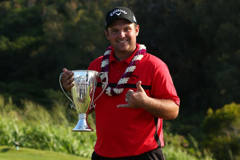 Patrick Reed poses with the winner's trophy after his come-from-behind win in the Hyundai Tournament of Champions in Kapalua, Hawaii.