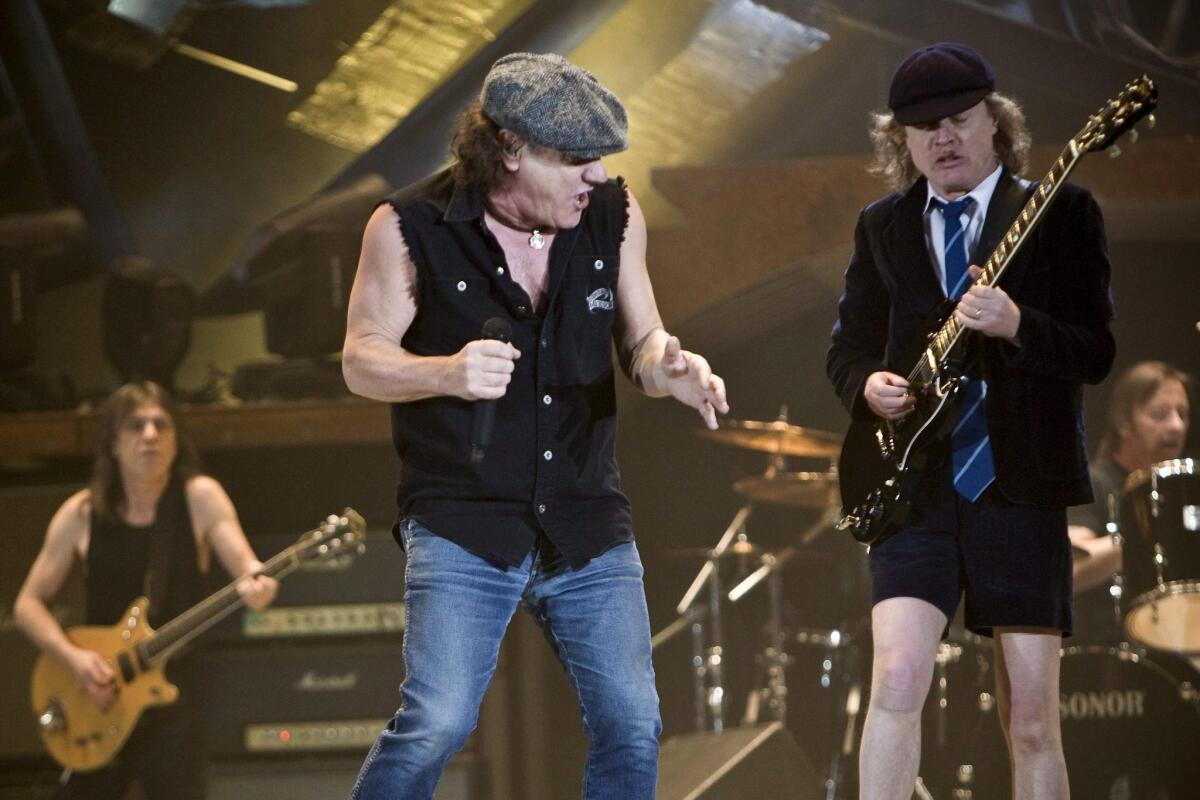 AC/DC lead singer Brian Johnson, center, Scottish guitarist Malcom Young, left, and his brother Angus Young, shown performing in Switzerland in 2009. Johnson has dismissed reports that the group is disbanding because of Malcolm Young's health.