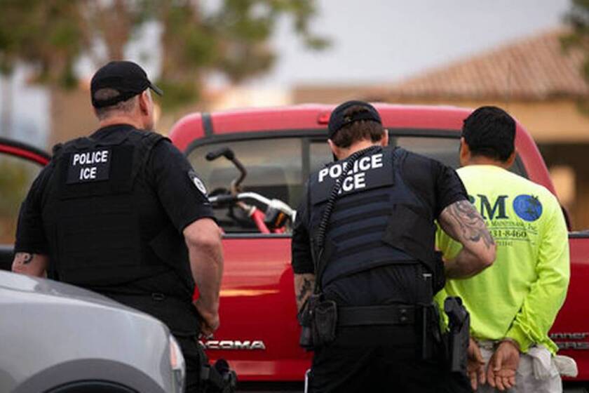 Agentes del Servicio de Control de Inmigración y Aduanas detienen a un hombre durante un operativo en Escondido, California.