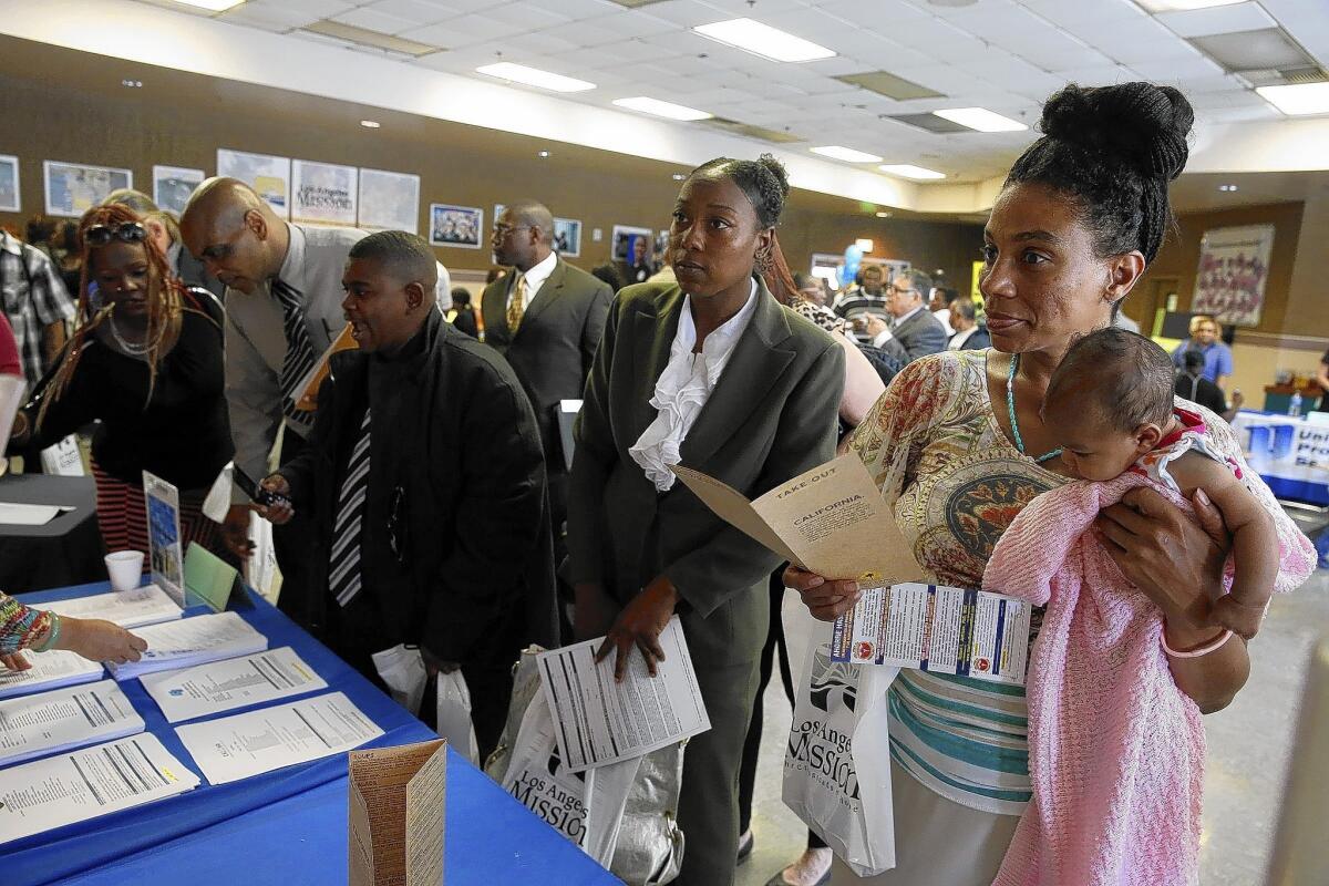 Dorianna Lyde holds her daughter while looking for work at the Skid Row Career Fair in Los Angeles.