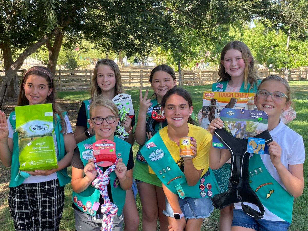Ramona Girl Scouts from Troops 2757 and 2933 showing off some of the donations collected for their pet food and supply pantry