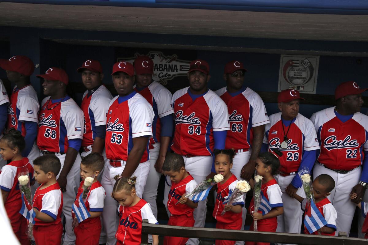 Cuba's national team and young fans await opening ceremonies for the exhibition game with the Tampa Bay Rays, attended by Presidents Obama and Castro.