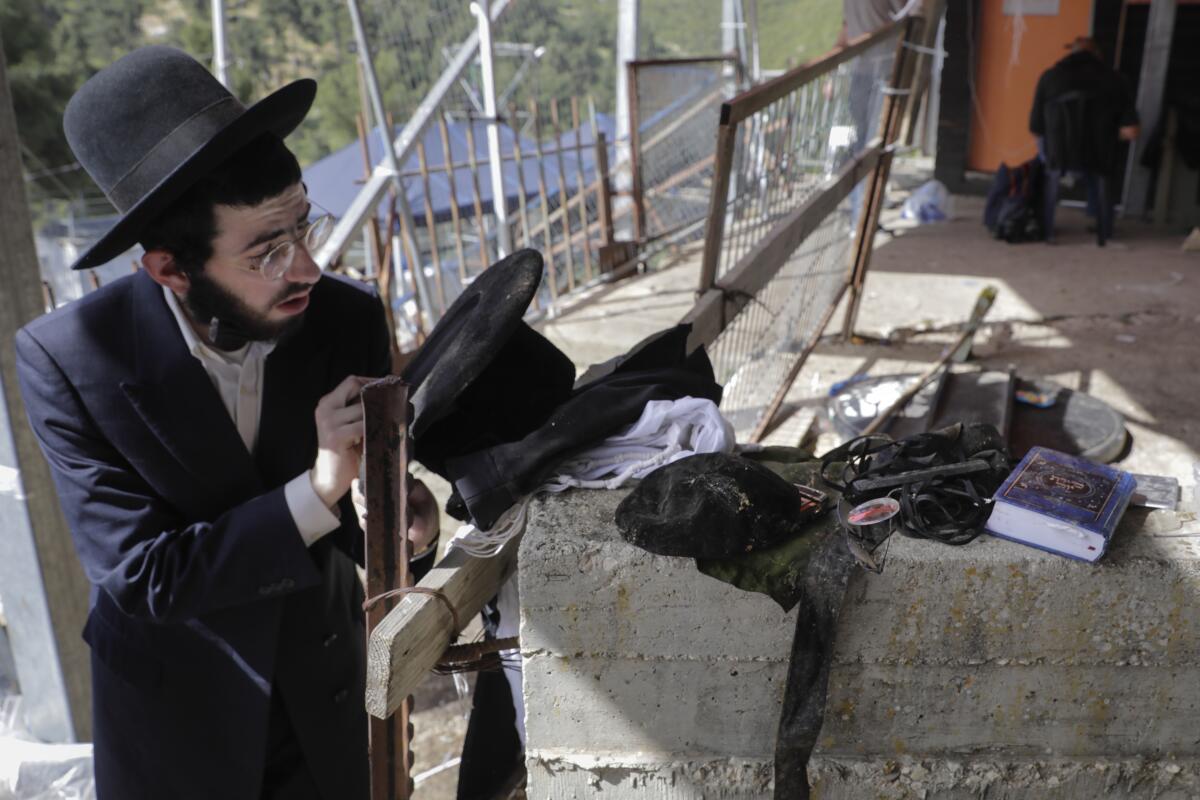An ultra-Orthodox Jewish man stands beside a wall