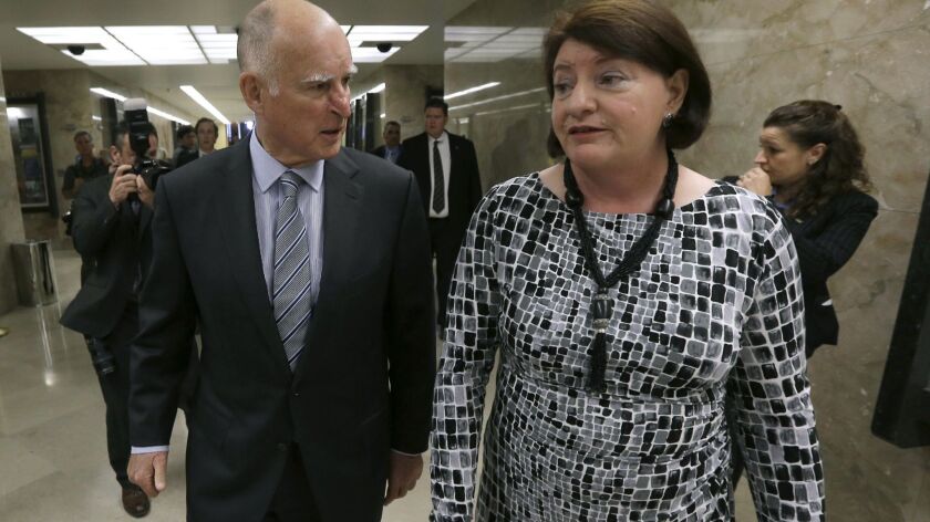Gov. Jerry Brown talks to Senate leader Toni Atkins of San Diego after a 2015 news conference. Atkins wrote a bill to require corporate boards to include women.