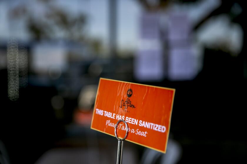 A sign indicates that a table has been cleaned at Saffron Thai on May 21, 2020 in San Diego, California. Restaurants began reopening for dine-in patrons on Thursday as the state and county began easing restrictions imposed during the coronavirus pandemic.