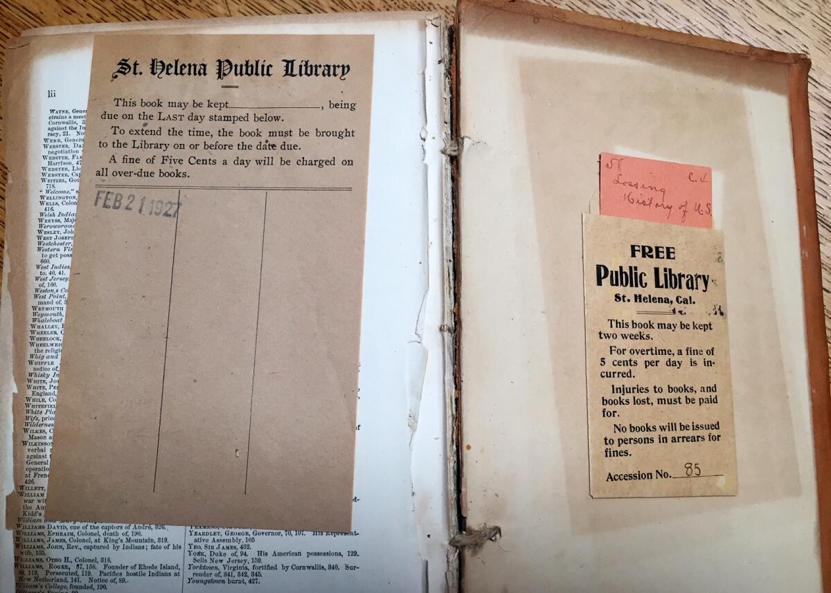 A worn book opened to its last page, with a public library note-pocket on the right