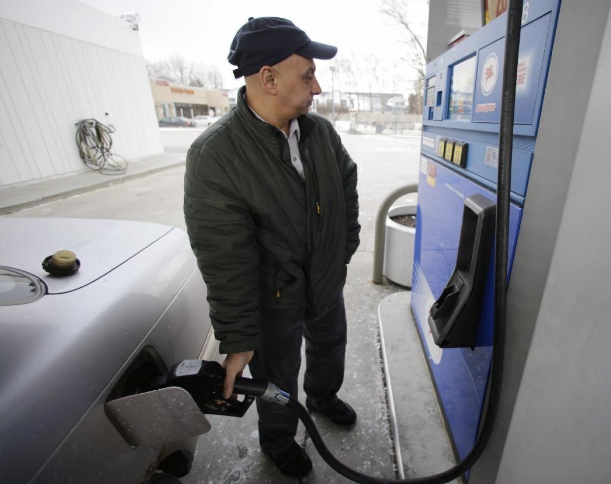 Samir Shabo fills up his tank at a Mobil gas station in Chicago. In 2012, the percentage of household income that Americans spent on gasoline hit a 30-year high, the Energy Department says.