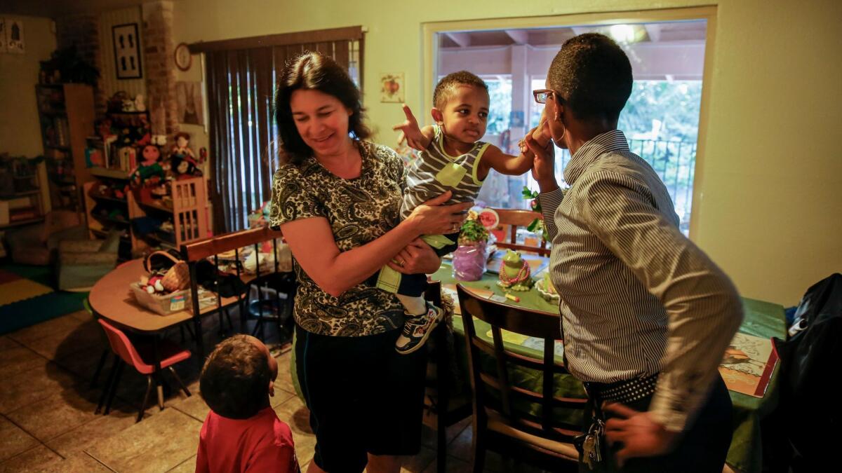 Brown kisses Samson goodbye, while Samuel tries to get the attention of Virginia Perez, their day care provider.