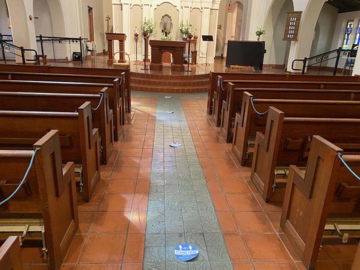 Sacred Heart Church of Ocean Beach has pews roped off and placement mats on the floor to keep guests at a safe distance.