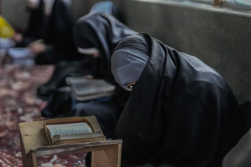 A Kashmiri Muslim girl reacts to camera as she attends recitation classes of the holy Quran during the fasting month of Ramadan in Srinagar, Indian controlled Kashmir, Sunday, March 26, 2023. (AP Photo/Mukhtar Khan)
