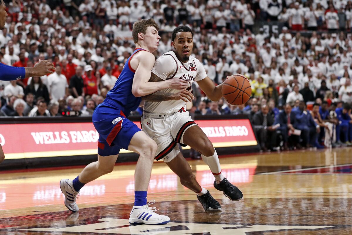 FILE - Texas Tech's Kyler Edwards (0) drives against Kansas' Christian Braun (2) during the second half of an NCAA college basketball game n Lubbock, Texas, in this Saturday, March 7, 2020, file photo. Texas Tech is technically still the reigning national runner-up since there was no NCAA Tournament played last season. The Red Raiders were on the floor warming up for their Big 12 tournament opener last March when the season suddenly stopped because of the novel coronavirus pandemic. (AP Photo/Brad Tollefson, File)