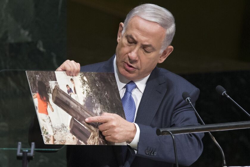 Israel's Prime Minister Benjamin Netanyahu points to a photo he says shows rocket launchers placed in residential neighborhoods of Gaza, as he addresses the 69th session of the United Nations General Assembly at U.N. headquarters on Monday.