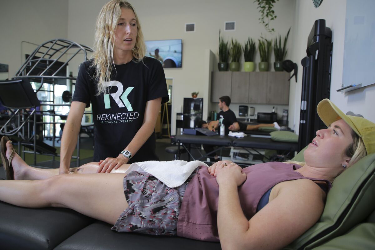 Physical therapist Nina Wheeler works on the rehabilitation of patient Jenna Richardson's right knee.