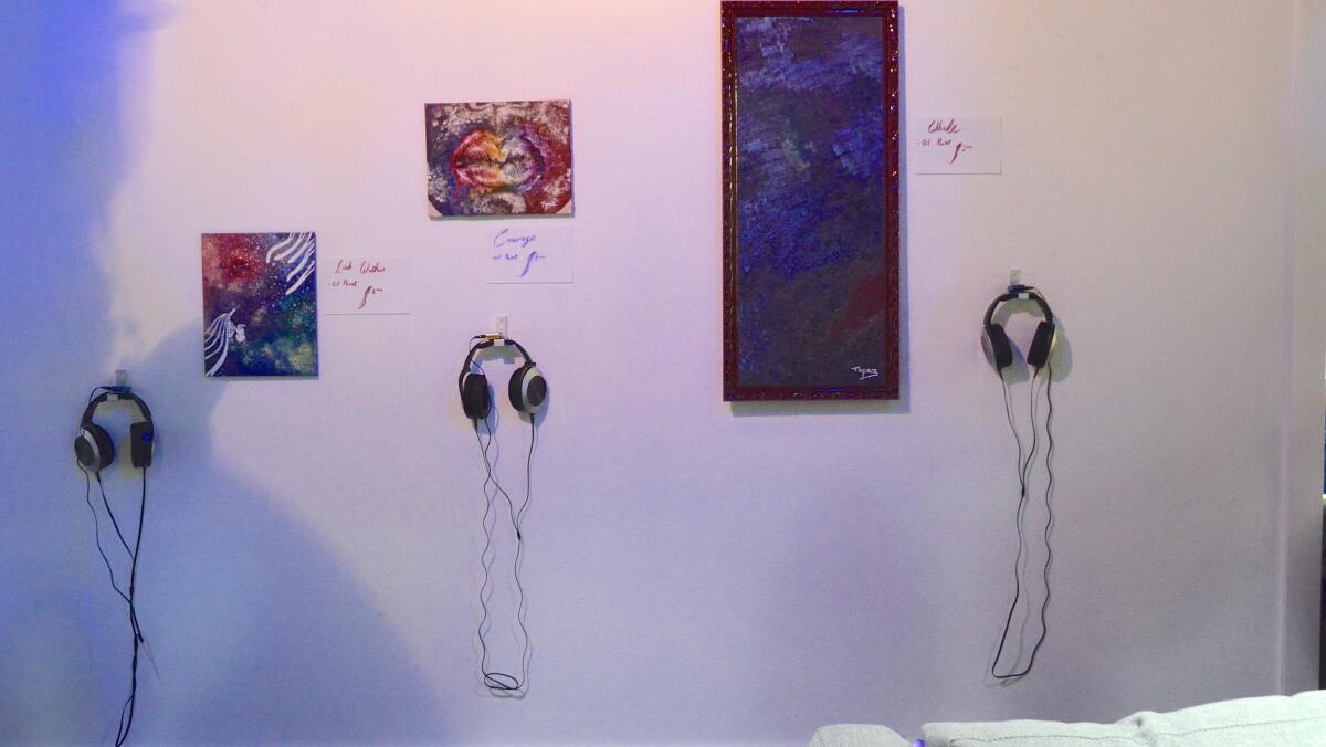 Headsets provide audio accompaniment to each oil painting, piano pieces that Topaz Peretz composed to her "Enthralled" collection.