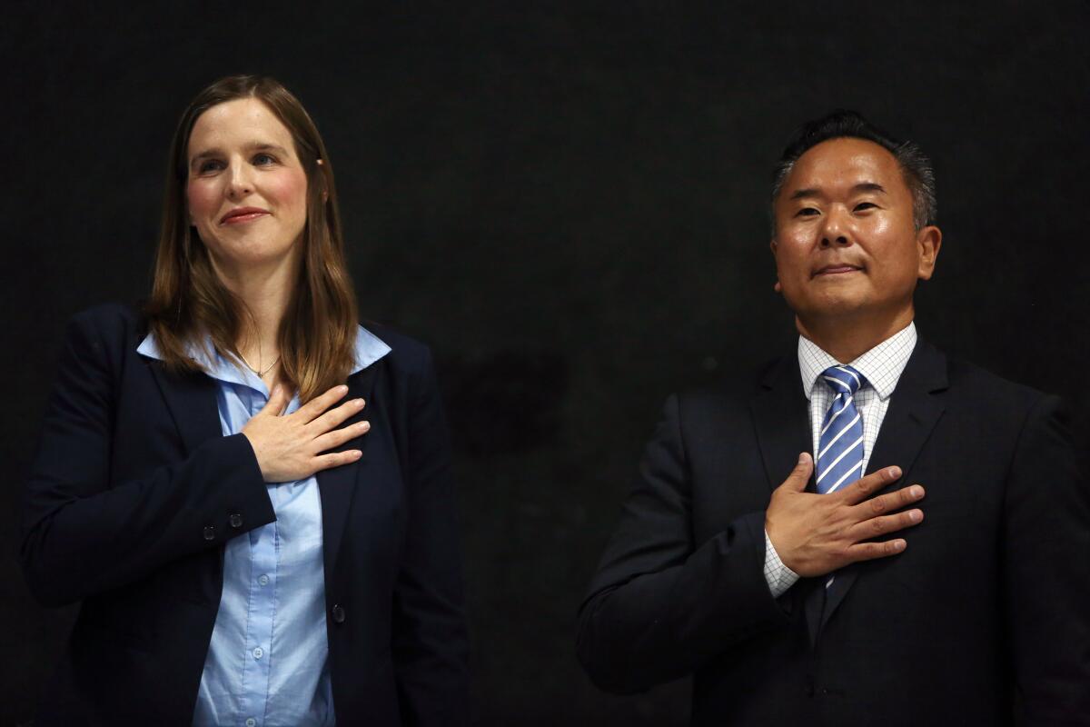 Loraine Lundquist, left, and John Lee during the pledge of allegiance during a Neighborhood Council Town Hall on July 20.