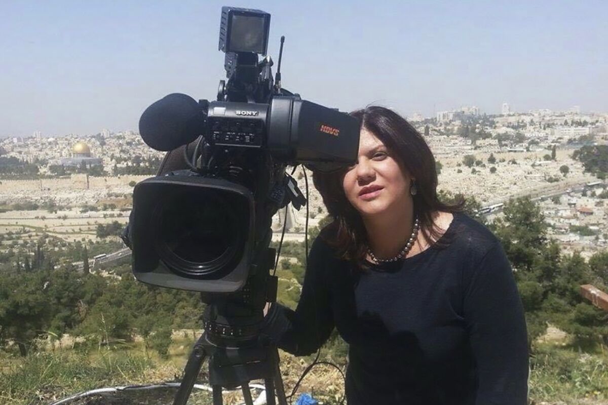Al Jazeera journalist Shireen Abu Akleh next to a camera.