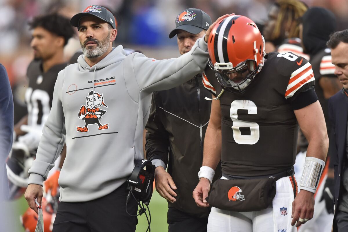 Cleveland Browns head coach Kevin Stefanski, left, touches the helmet of quarterback Baker Mayfield (6) after an injury during the second half of an NFL football game against the Arizona Cardinals, Sunday, Oct. 17, 2021, in Cleveland. (AP Photo/David Richard)