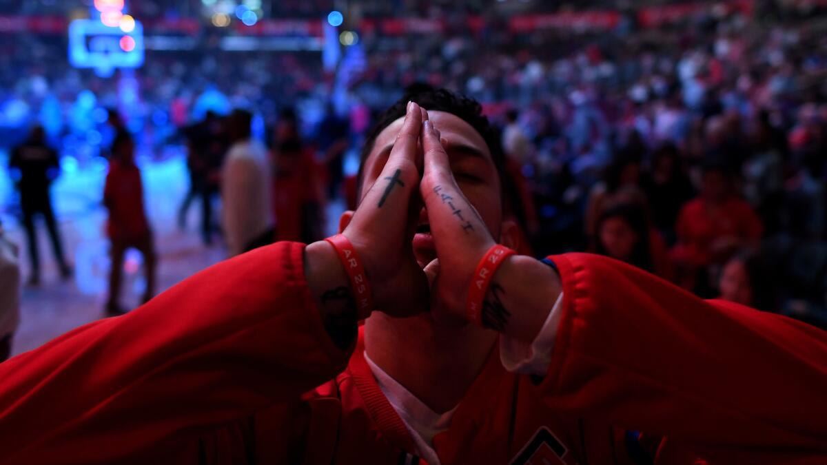 Clippers Austin Rivers prays before a game against the Bucks.