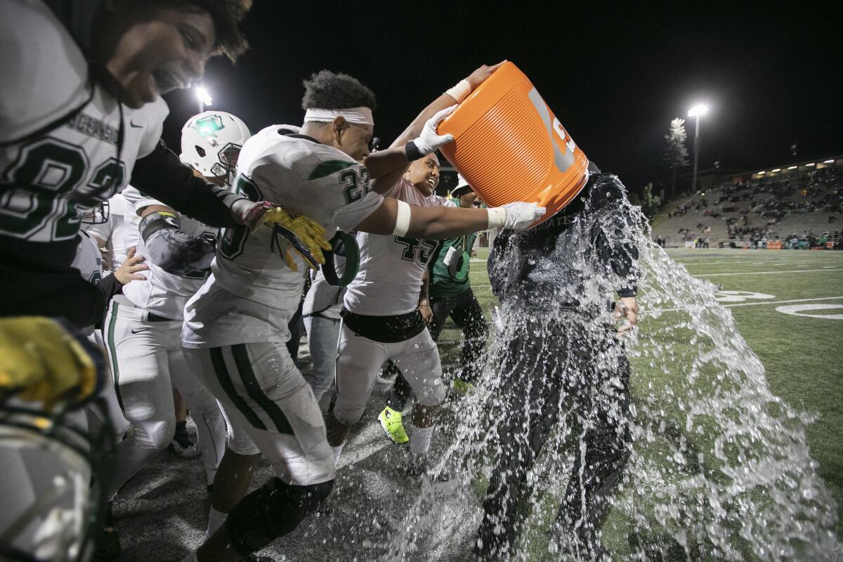 Oceanside players douse head coach David Rodriguez with water after winning the Division 1 football title game in 2019.
