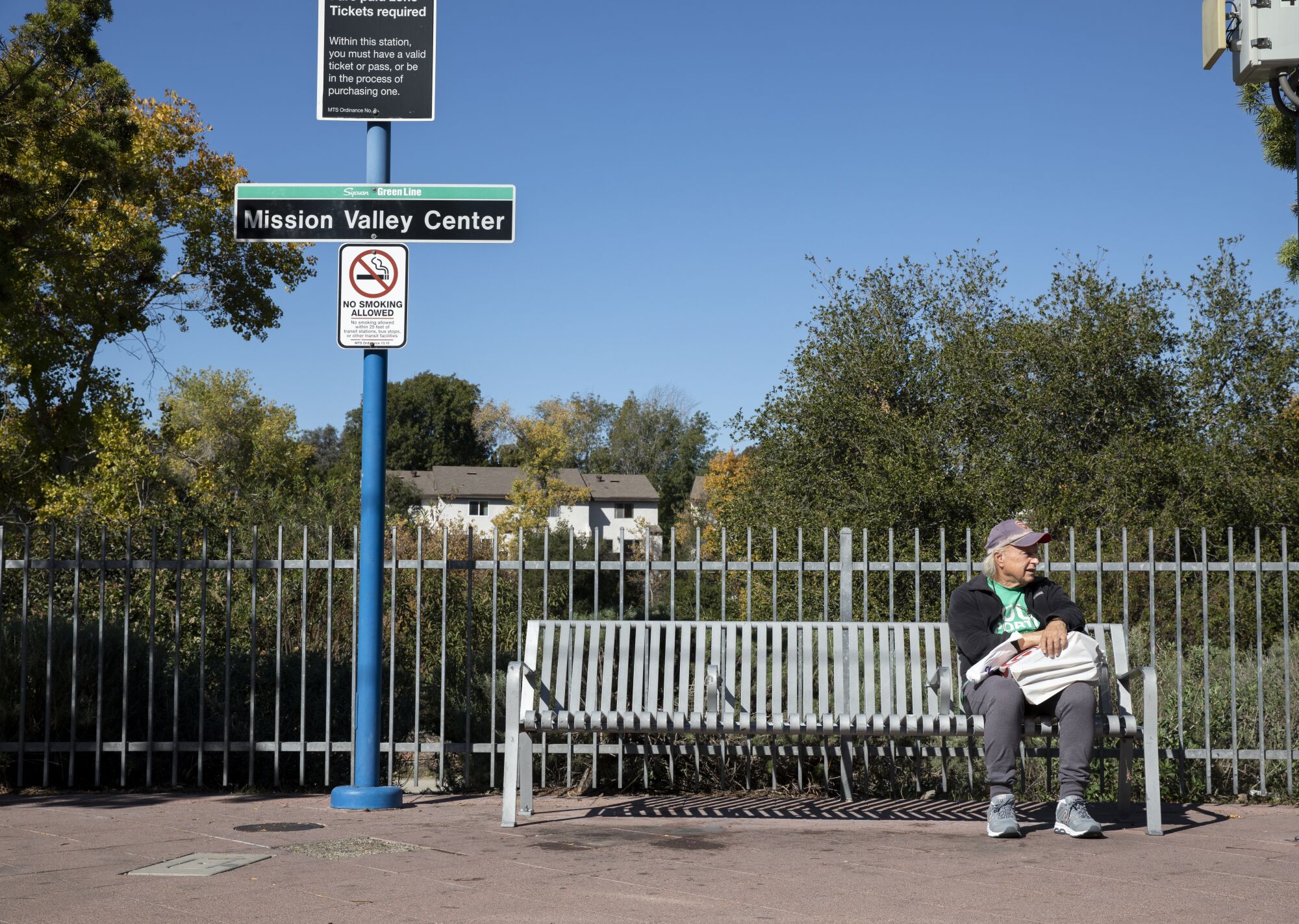 Jim Morse waits to board the San Diego Trolley's green line at the Mission Valley Center station