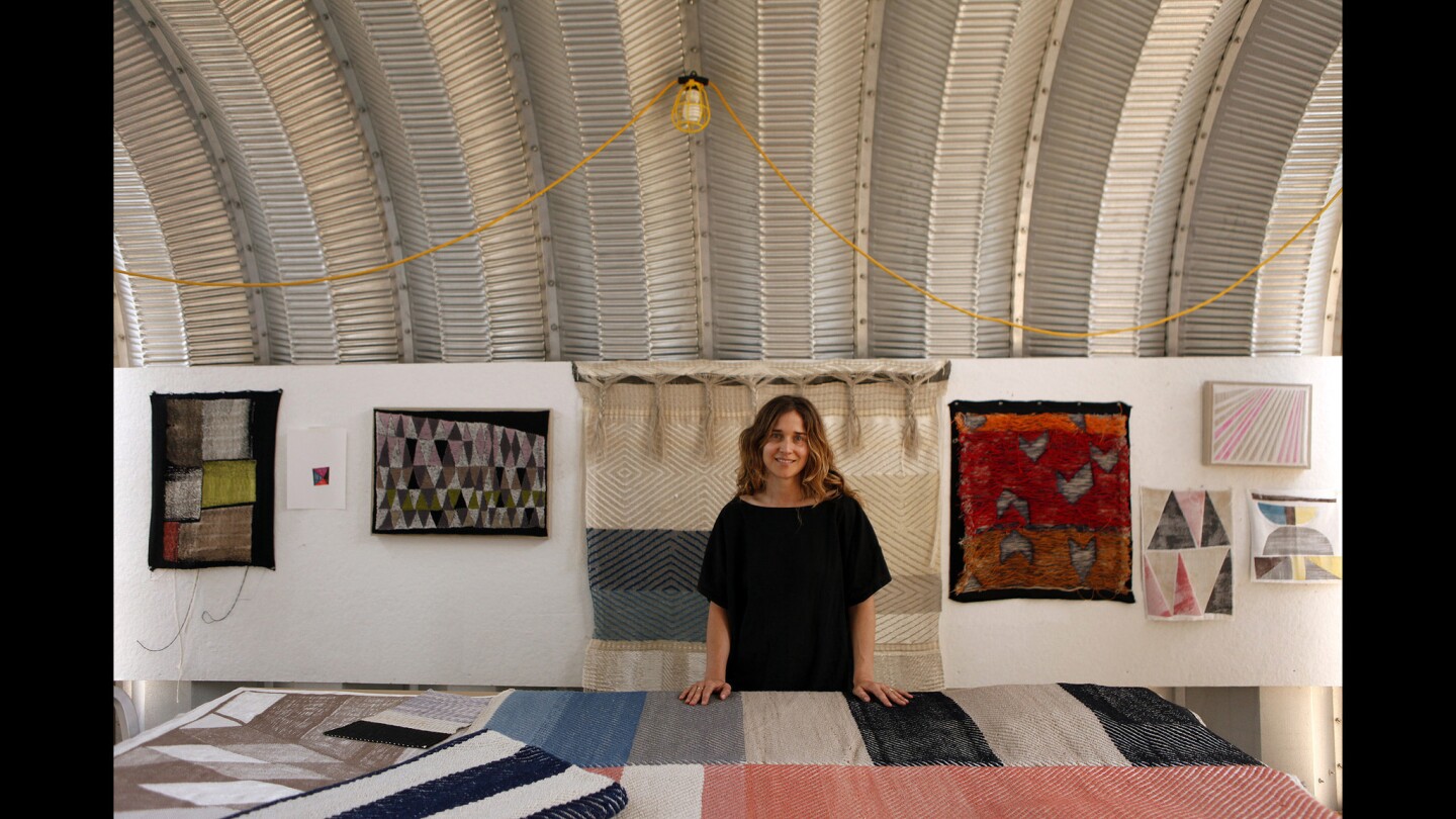 Christy Matson is surrounded by some of her textile creations in her studio in Highland Park, where she works on a Jacquard loom.