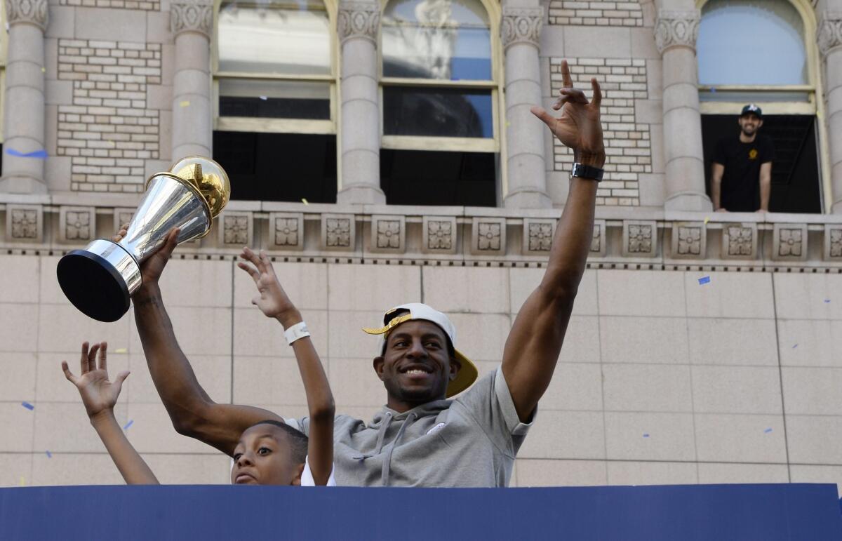 Golden State Warriors player and NBA Finals MVP Andre Iguodala holds up the trophy while acknowledging the crowd during the Warriors 2015 NBA Championship Parade and Rally in downtown Oakland.