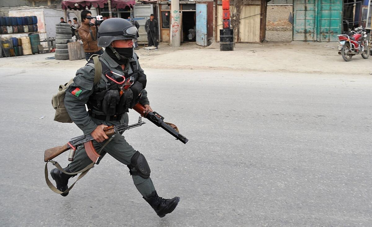 An Afghan policeman responds to a suicide attack on the Kabul Jalalabad road in Kabul on Friday. A suicide attacker detonated an explosives-packed car next to a NATO military convoy in Kabul, killing three NATO personnel and injuring at least seven civilians, authorities said.