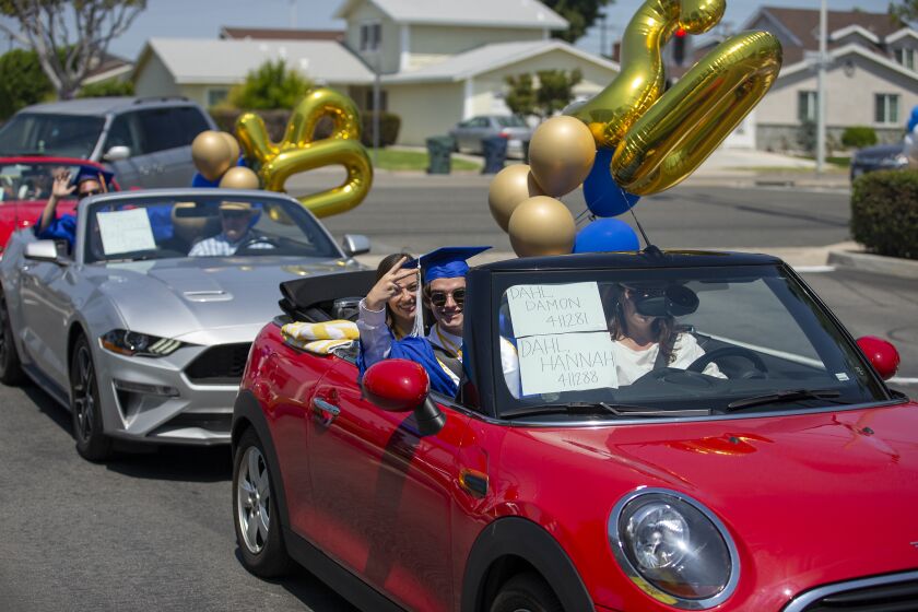 Damon Dahl and his sister Hannah wait in line during a drive-thru graduation at Fountain Valley High School on Wednesday, June 10.