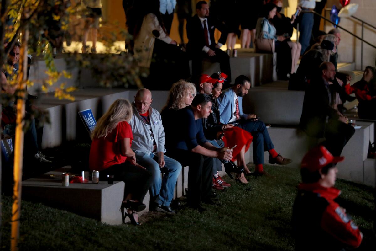 People sit outdoors at an election night watch party