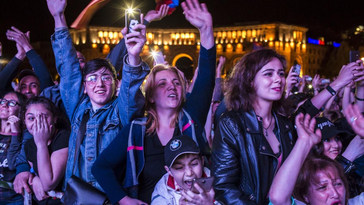 People cheer at a gathering in Yerevan, Armenia, to hear protest leader Nikol Pashinian speak on the eve of his expected election as prime minister.