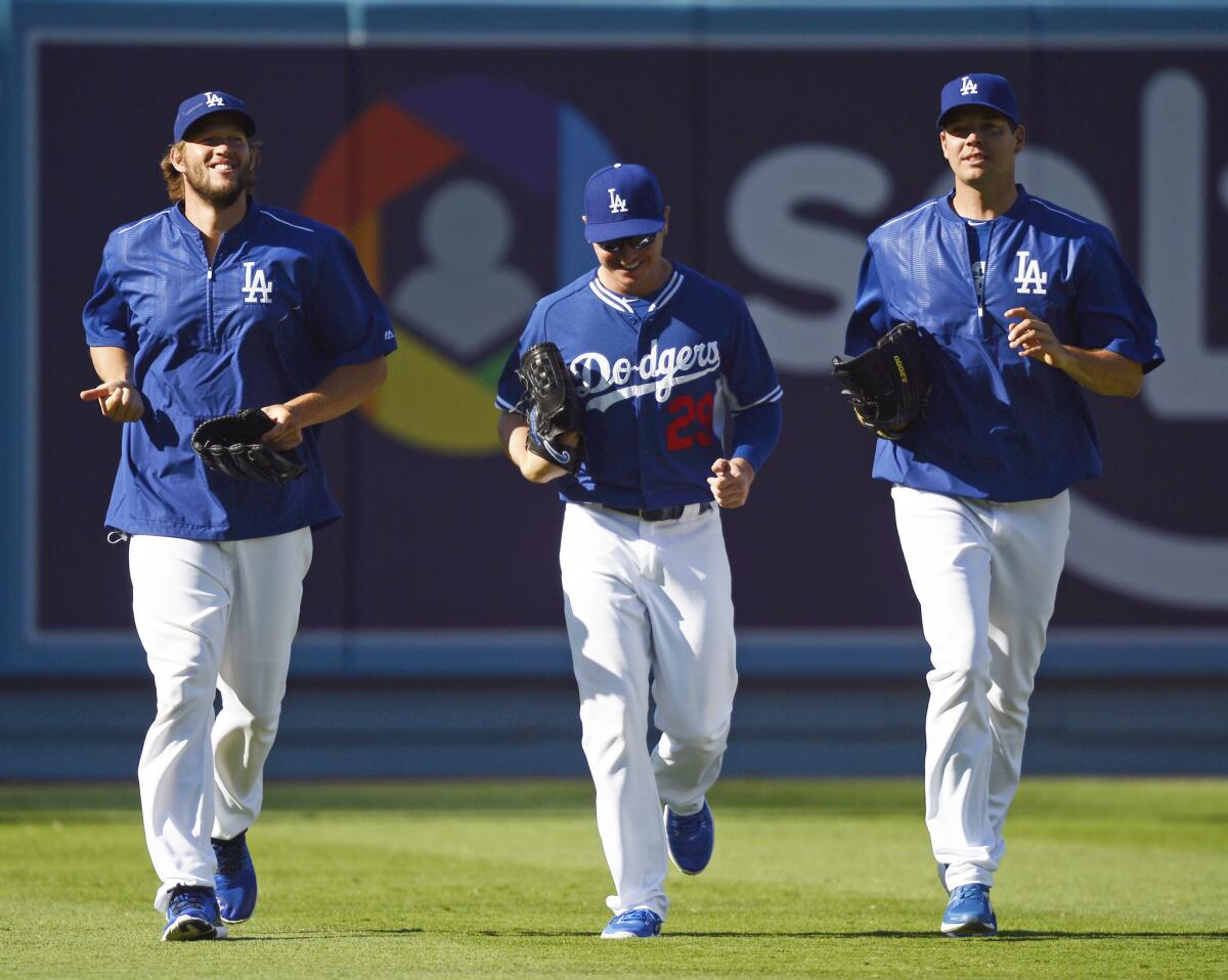 Clayton Kershaw (22), Scott Kazmir (29) and Rich Hill (44) jog during batting practice prior to a game against the Philadelphia Phillies at Dodger Stadium on Aug. 9.