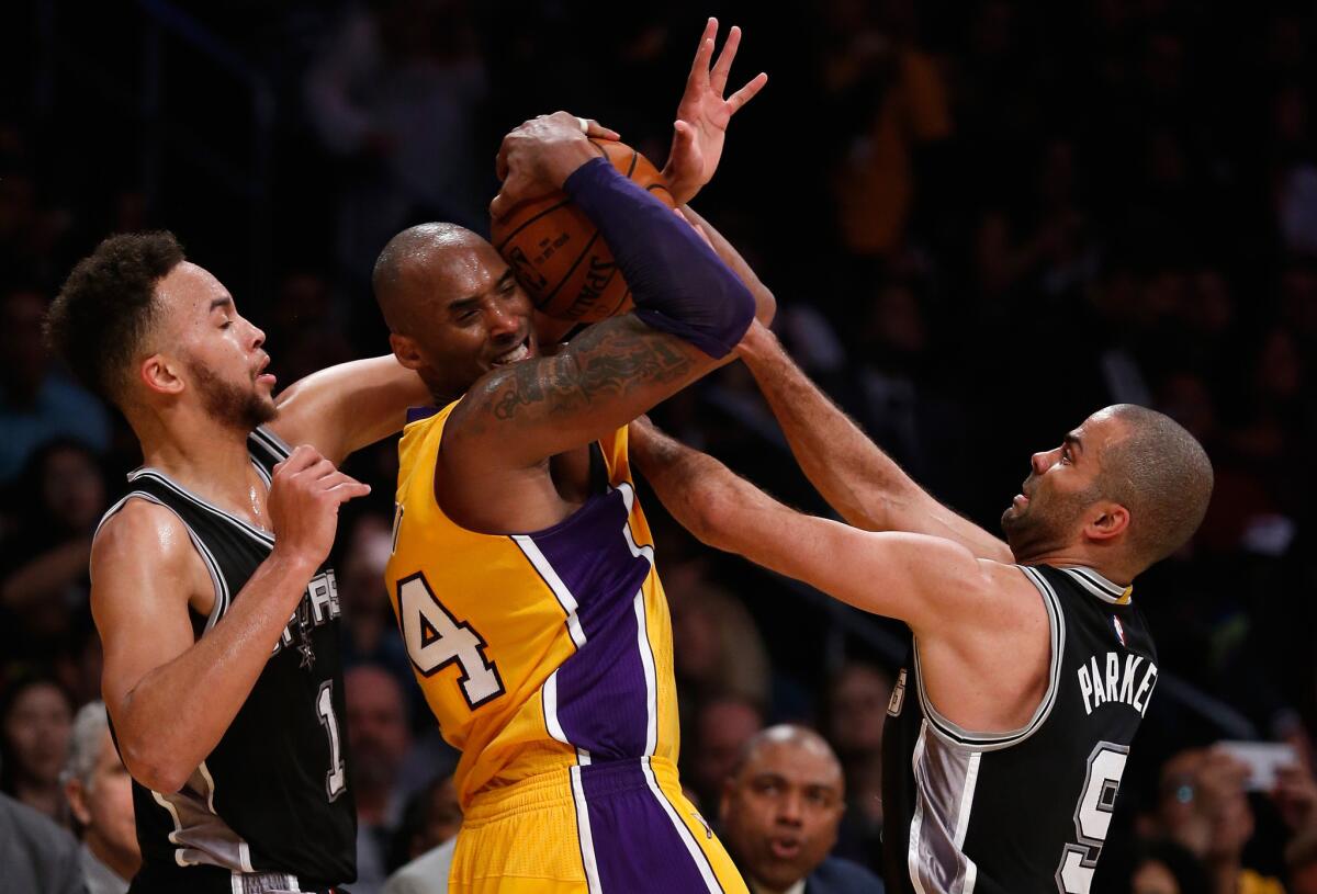 Lakers forward Kobe Bryant fights Spurs forward Kyle Anderson, left, and guard Tony Parker for the ball during the second half.