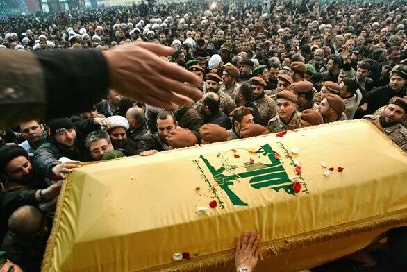 Hezbollah fighters carry the coffin of their slain top commander, Imad Mughniyah, during his funeral procession in Lebanon on Thursday. The coffin is draped in the group's flag. Hezbollah has vowed to retaliate against Israel for Mughniyah's death, though Israel has denied orchestrating the Tuesday attack in Syria.