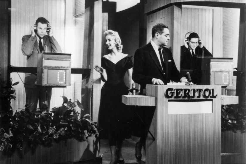 Scene from 1950s tv show"Twenty-One" with contestant Charles Van Doren on left. Host Jack Berry is in middle and other contestant is Herbert Stempel on right. Photo from press release for PBS televsion show The American Experience episode "The Quiz Show Scandal."