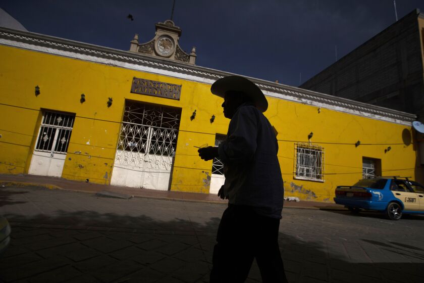 ARCHIVO - Un cliente sale de un banco donde la gente recibe transferencias internacionales de dinero en Acatlán de Osorio, México, el 27 de junio de 2020. (AP Foto/Fernando Llano, Archivo)