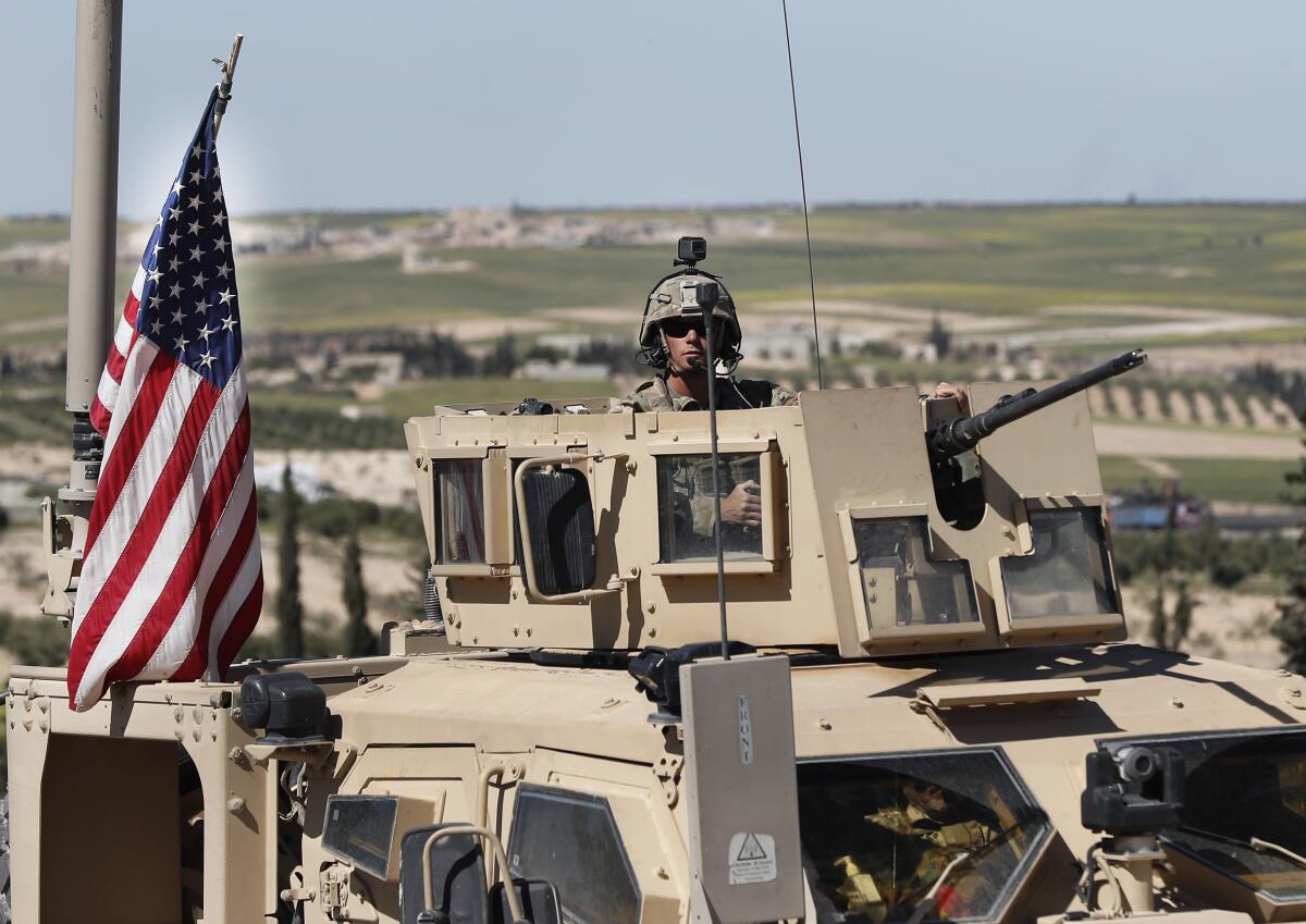 A U.S. soldier sits in an armored vehicle 