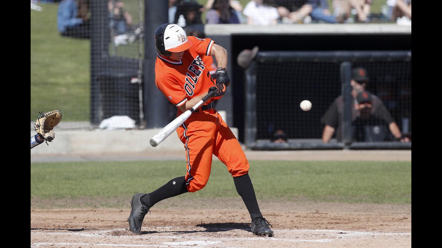 Huntington Beach High's Jake Vogel hits a two-run homer against Fountain Valley during the first inning in a Surf League game at Huntington Beach High on Friday, March 15, 2019.