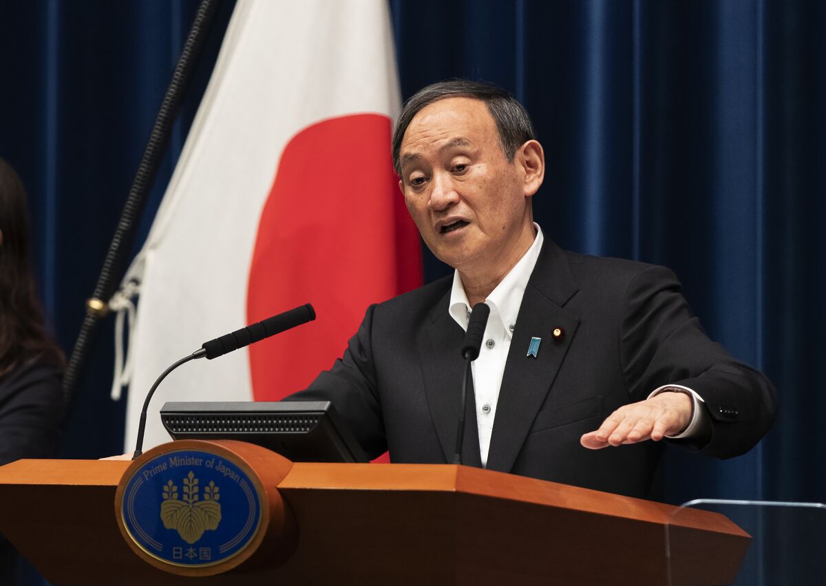 Japanese Prime Minister Yoshihide Suga responds to a reporter's question after he spoke at a news conference in Tokyo on Friday, May 7, 2021. Suga announced an extension of a state of emergency in Tokyo and other areas through May 31. (AP Photo/Hiro Komae)