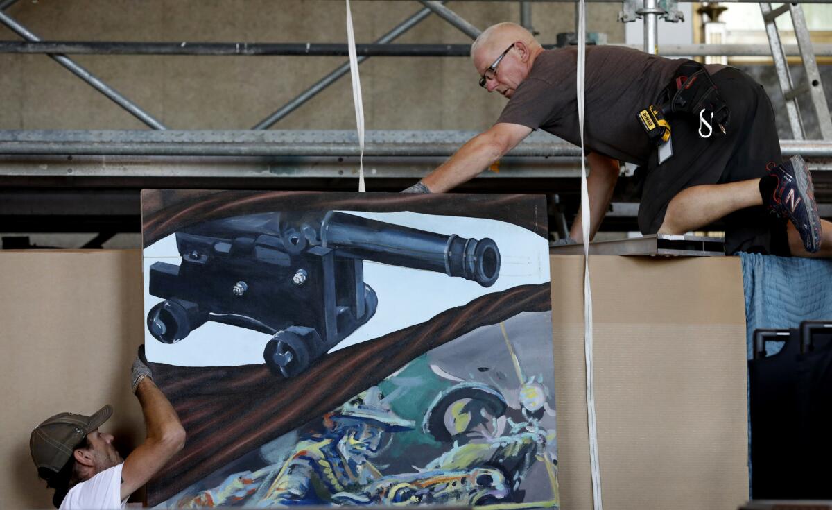 Kevan Overend, left, and Alan Bolger work on putting another panel into place. This one depicts a cannon used to defend the city in the Mexican American War.