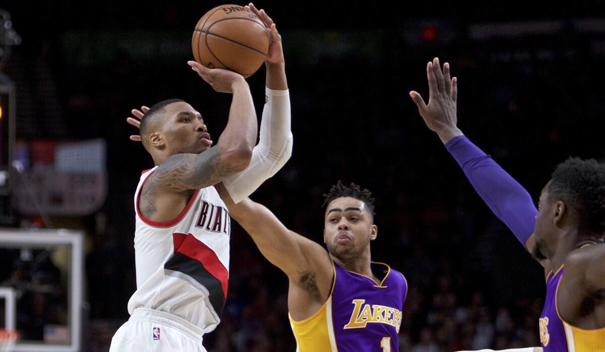 Portland Trail Blazers guard Damian Lillard, left, shoots over Lakers guard D'Angelo Russell, center, and forward Julius Randle during the second half on Jan. 5.