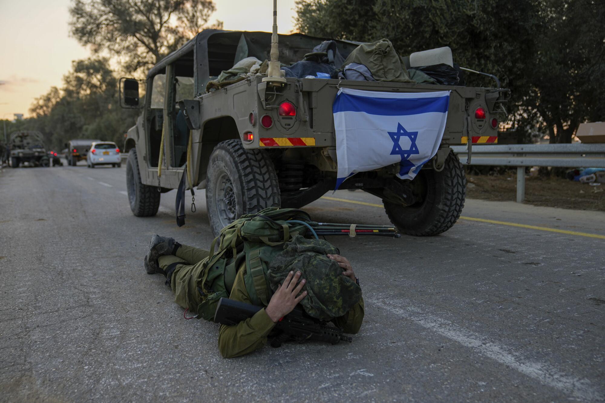 Israeli soldier lying on the ground, thinking he's heard an air-raid siren