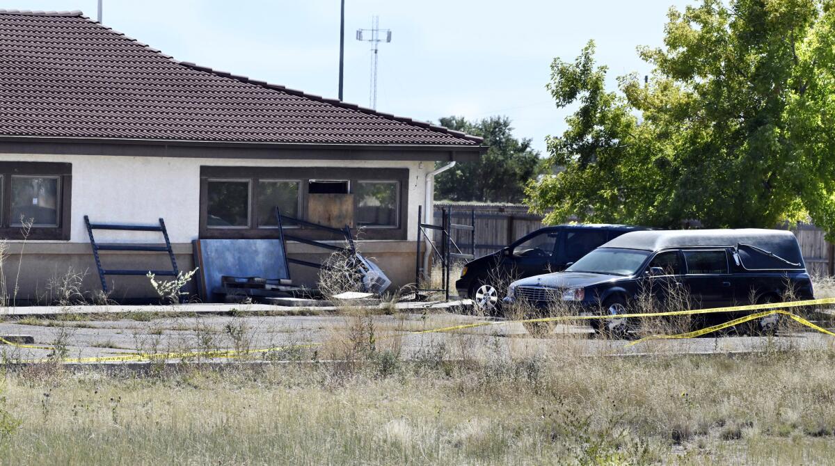 A hearse and debris outside a funeral home. 